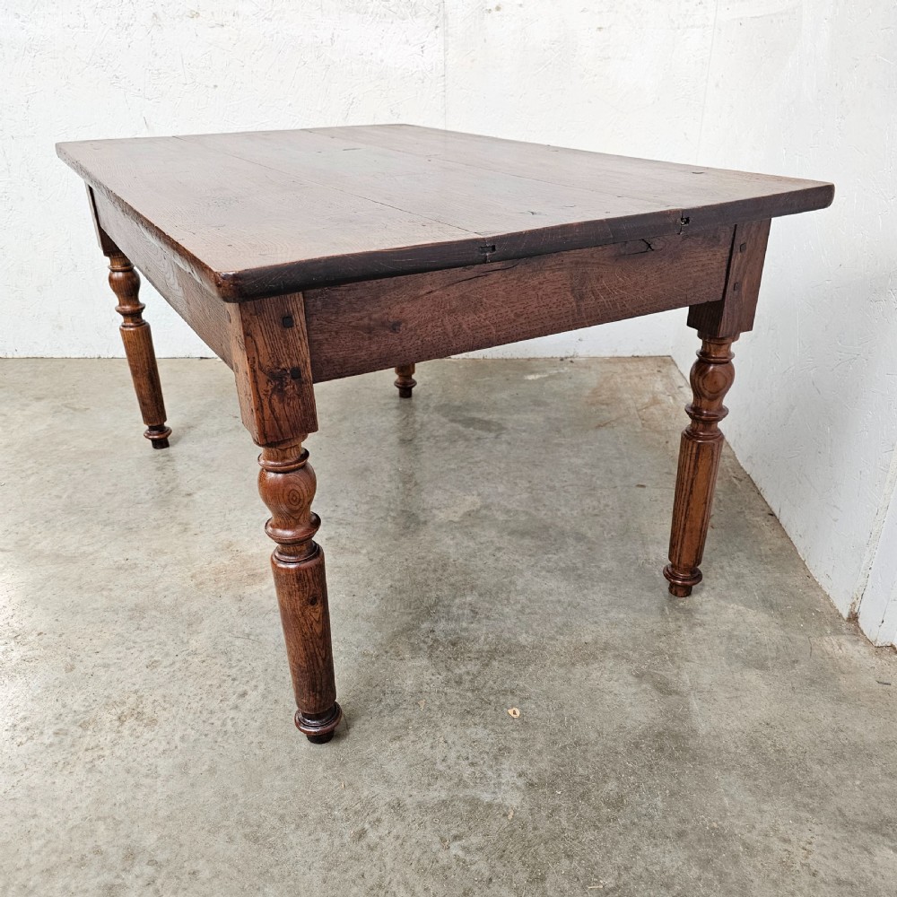 A low rectangular French oak table featuring a flat wooden top, deep apron, and four turned legs. View III