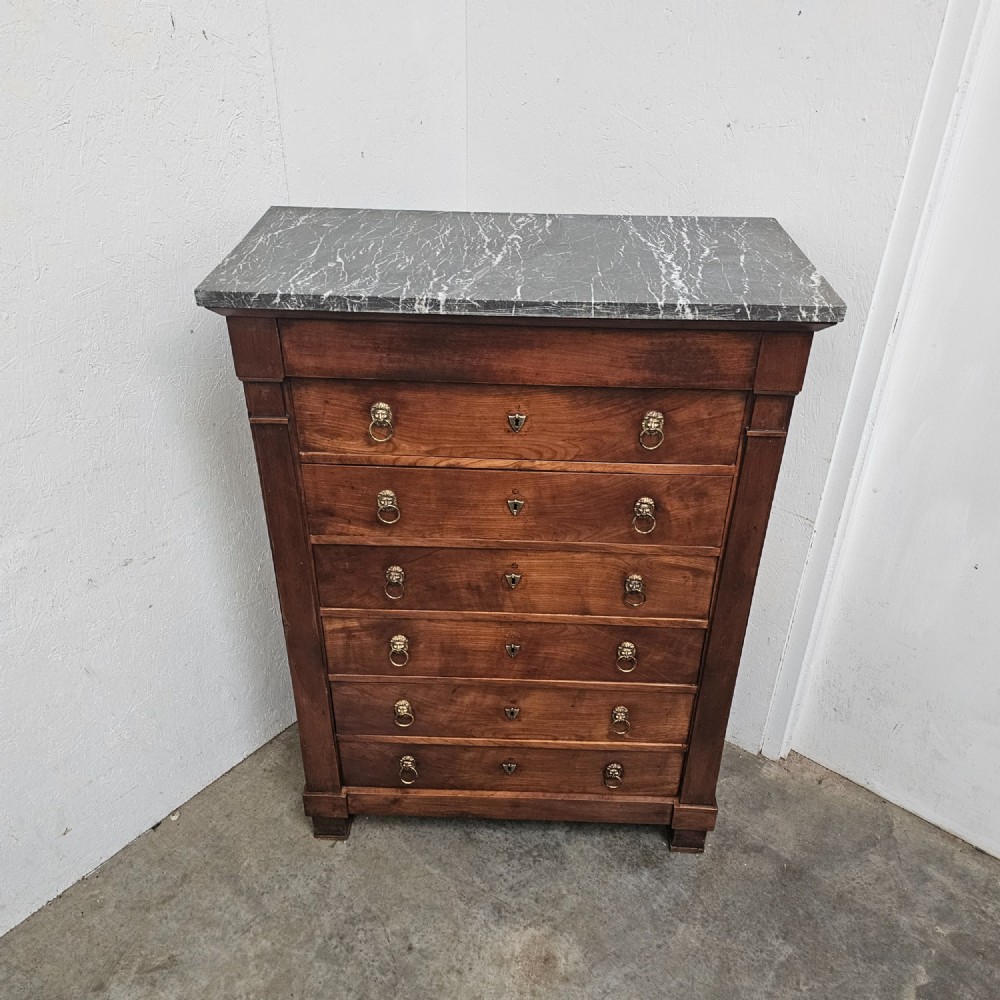 A nineteenth-century French cherry wood semainier featuring seven drawers with brass lion mask ring handles and a grey marble top. View VI