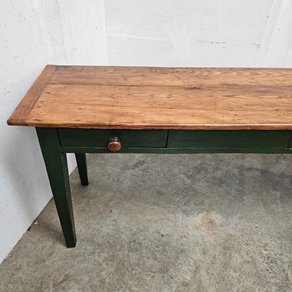 A long French painted pine console table featuring a natural wood plank top, a dark green painted base with tapered square legs, and three inline drawers with wooden knobs. View IV