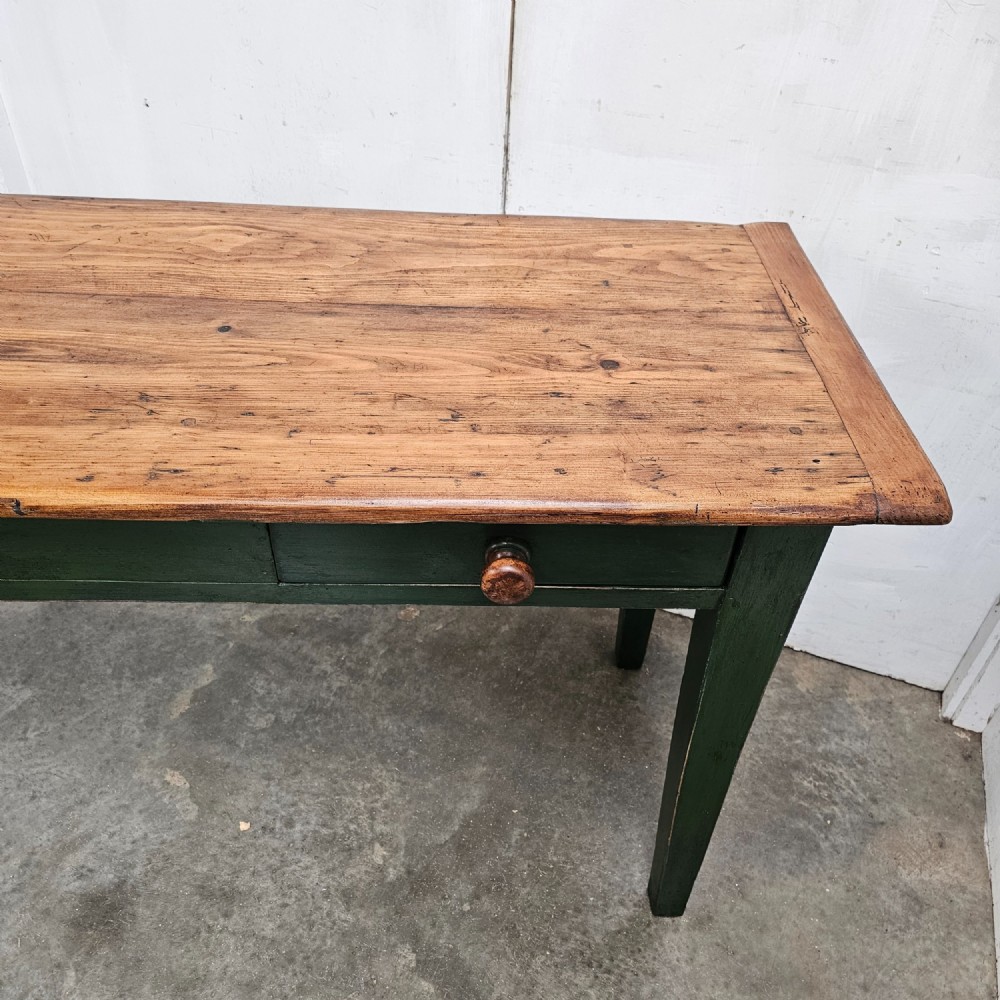 A long French painted pine console table featuring a natural wood plank top, a dark green painted base with tapered square legs, and three inline drawers with wooden knobs. View V