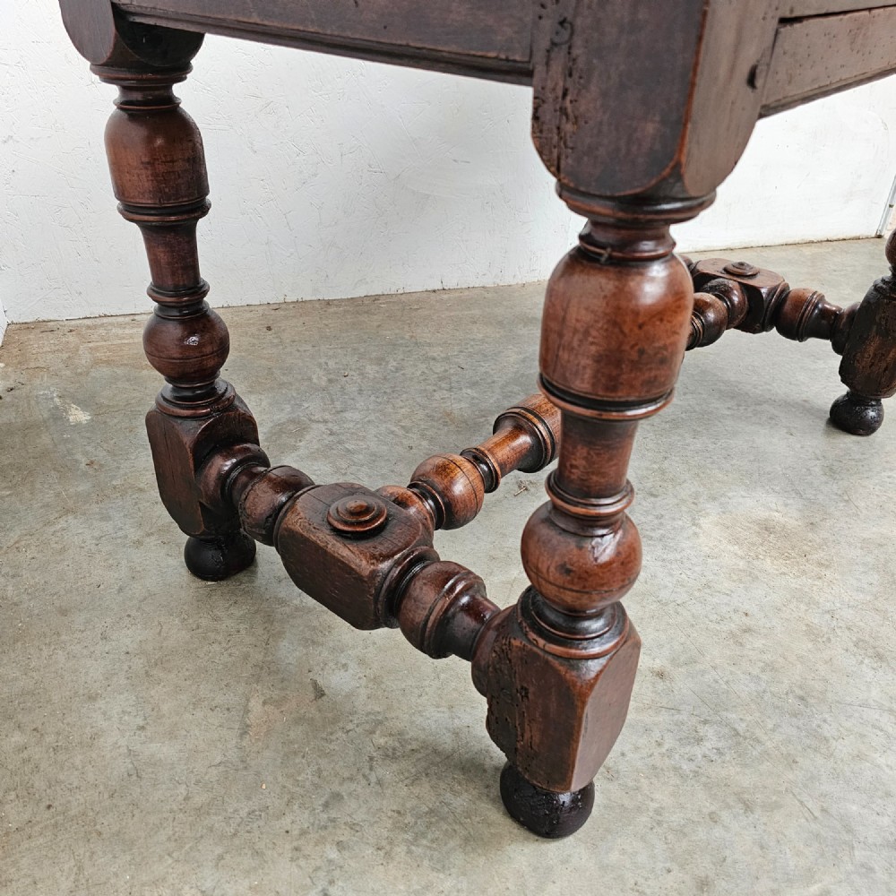 A warm brown cherry wood side table with turned legs, a low stretcher, and a single frieze drawer with a brass handle. View II