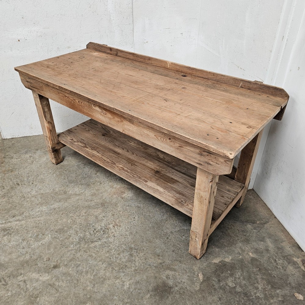 A rustic pine potting table featuring a raised rear upstand, sturdy square legs with a diagonal crossbrace, and a full-length lower timber shelf. View V