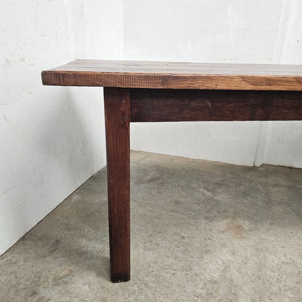 A long antique dark oak tavern table featuring a thick planked timber top supported by sturdy square legs. View V