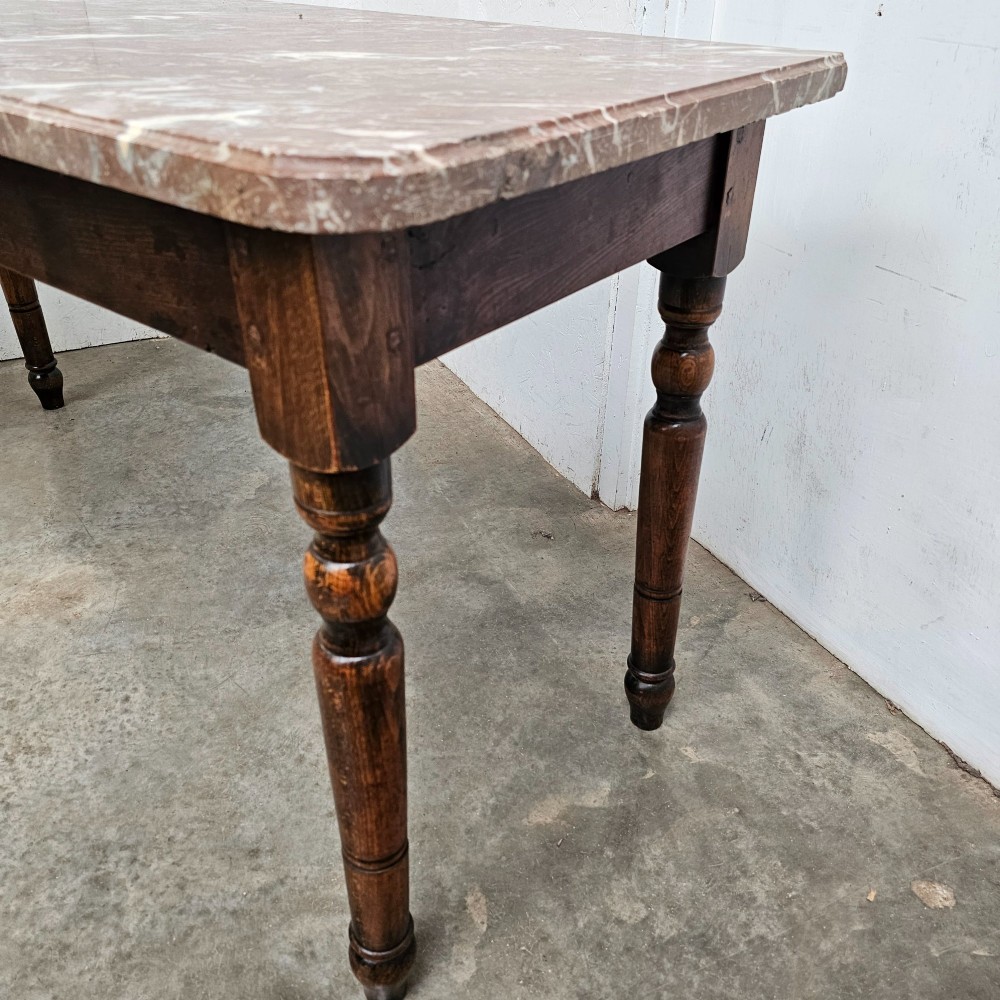 A French patisserie table featuring a thick reddish veined marble top supported by a dark wood frame with four turned legs. View II