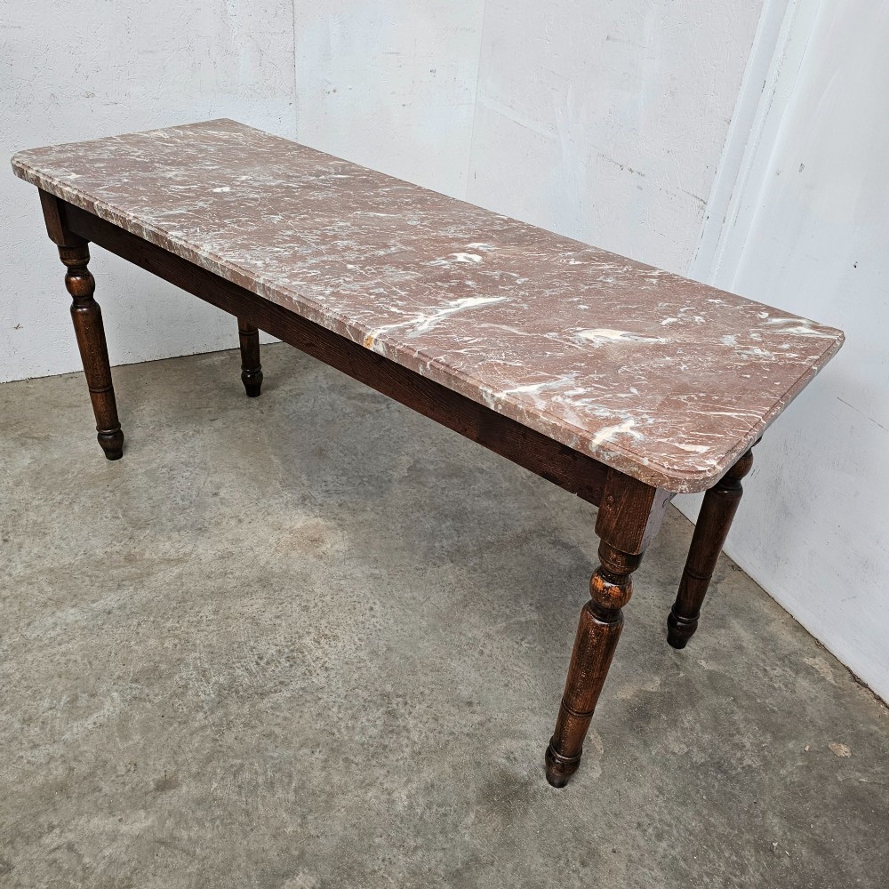 A French patisserie table featuring a thick reddish veined marble top supported by a dark wood frame with four turned legs. View III