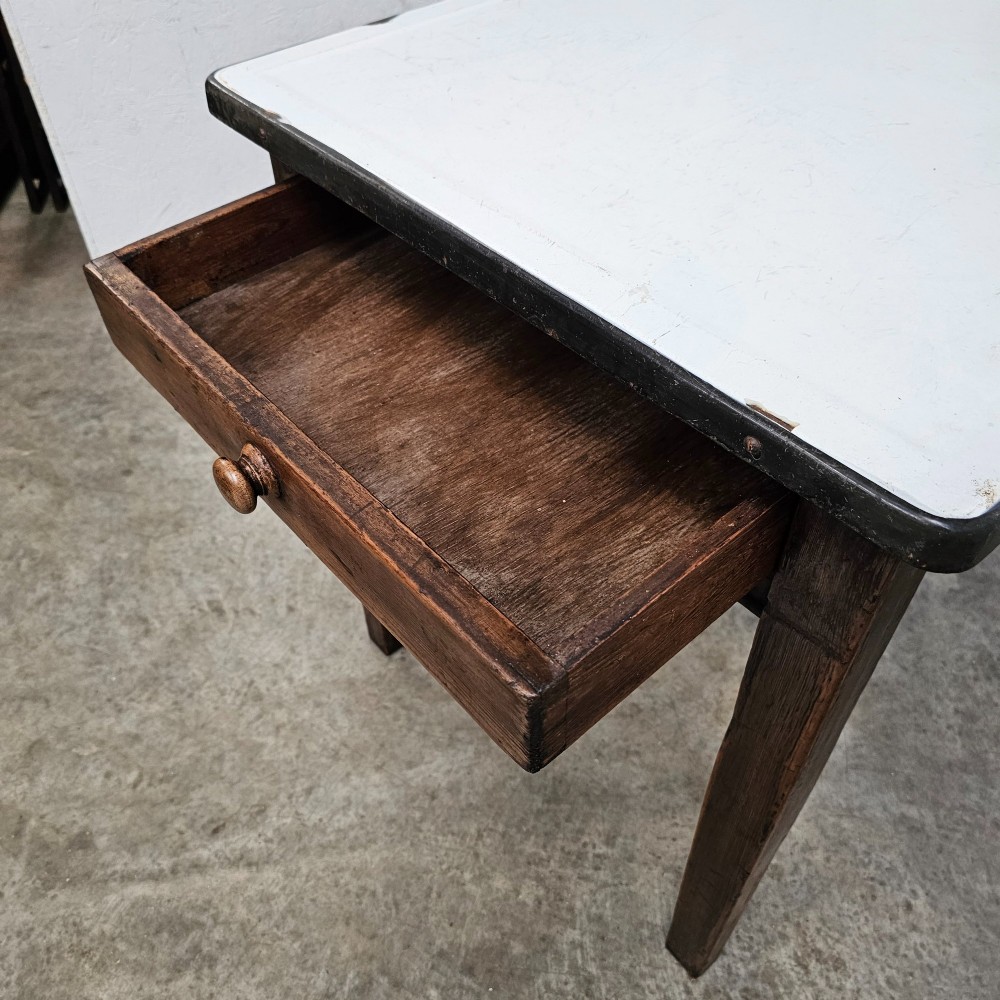 An early 20th-century dark oak kitchen prep table featuring a white vitreous enamel top and a single frieze drawer with a wooden knob. View III