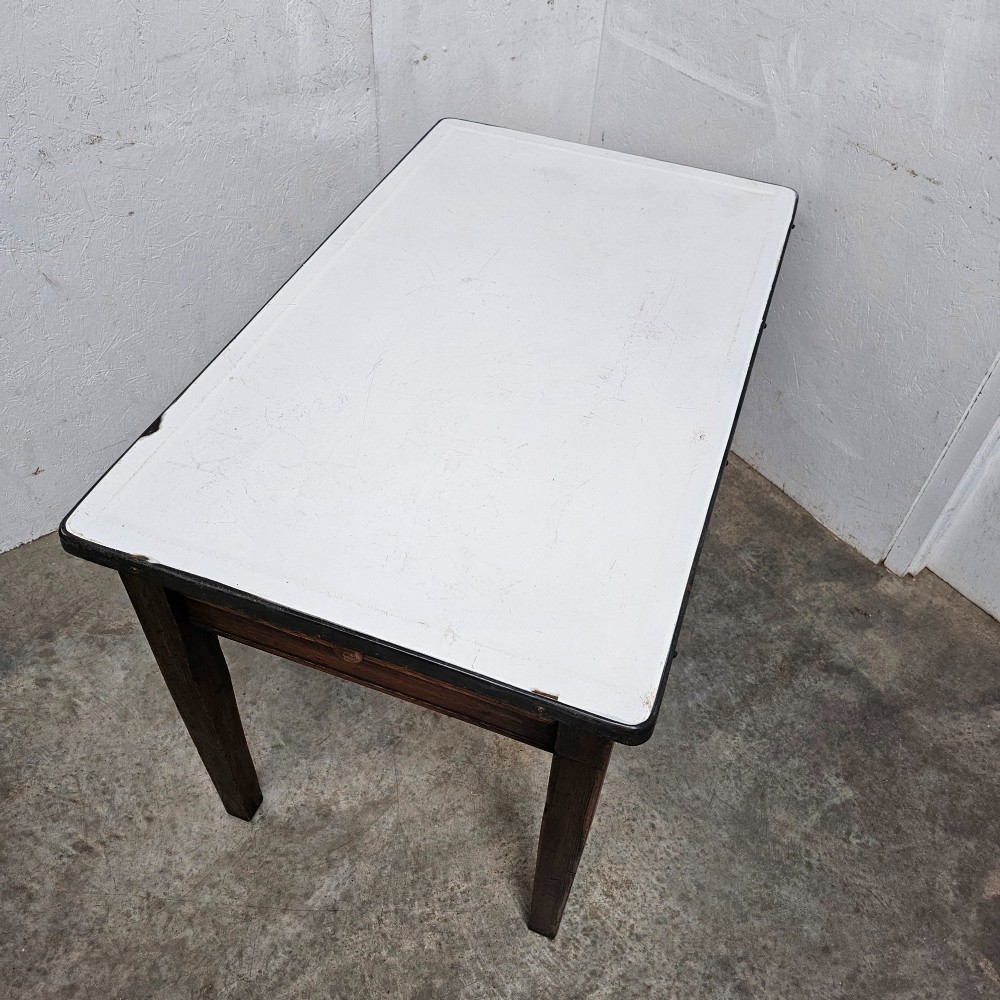 An early 20th-century dark oak kitchen prep table featuring a white vitreous enamel top and a single frieze drawer with a wooden knob. View IV