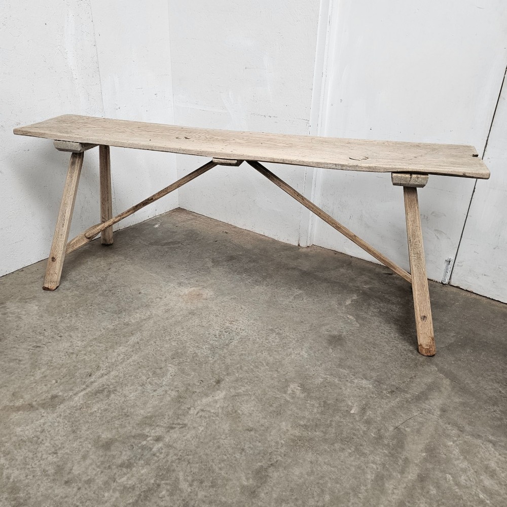 A long, narrow antique scrubbed pine console table featuring angled legs with diagonal cross-bracing and an unvarnished timber finish. View II