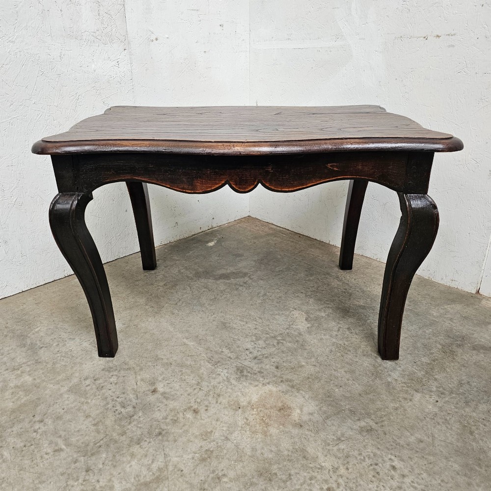 A dark brown French provincial chestnut low table featuring cabriole legs and a contoured apron.