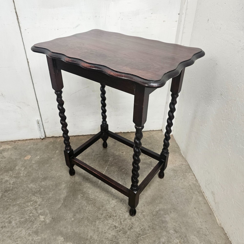 A dark oak side table with a scalloped pie-crust top, four barley-twist turned legs, and a square base stretcher. View IV
