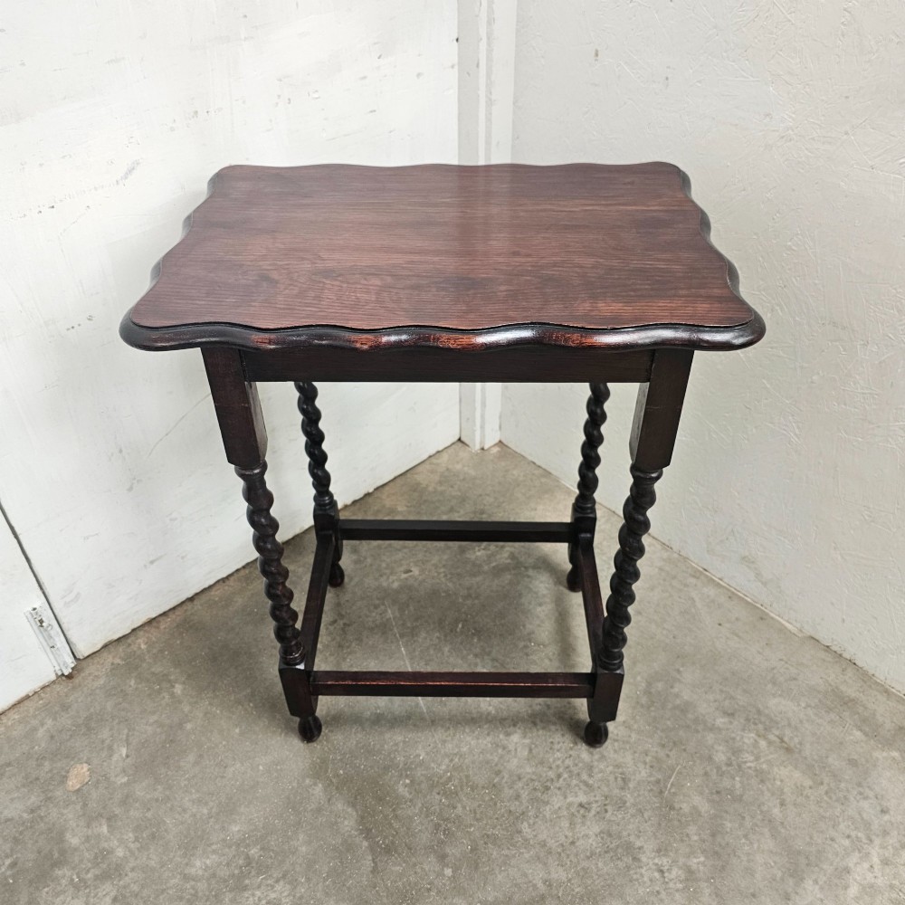 A dark oak side table with a scalloped pie-crust top, four barley-twist turned legs, and a square base stretcher. View V
