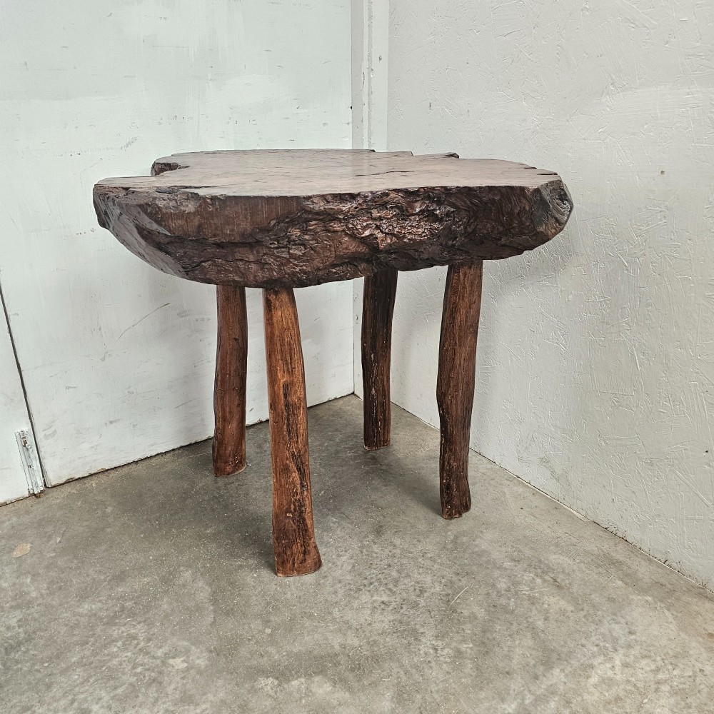 A primitive side table featuring a thick burr thuya timber slab top with natural live edges, supported by four simple wooden legs.