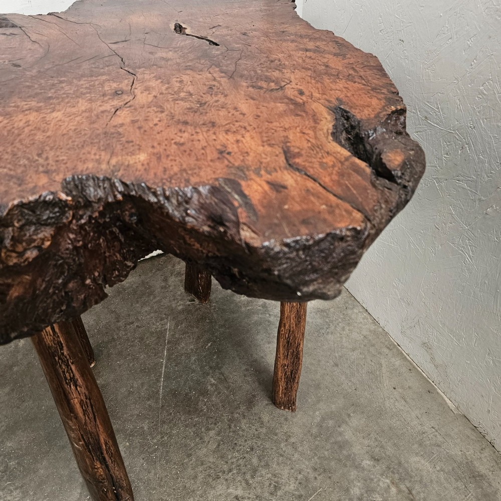 A primitive side table featuring a thick burr thuya timber slab top with natural live edges, supported by four simple wooden legs. View II