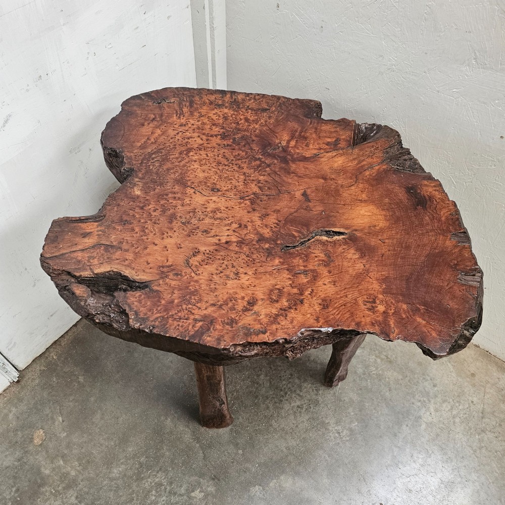 A primitive side table featuring a thick burr thuya timber slab top with natural live edges, supported by four simple wooden legs. View V