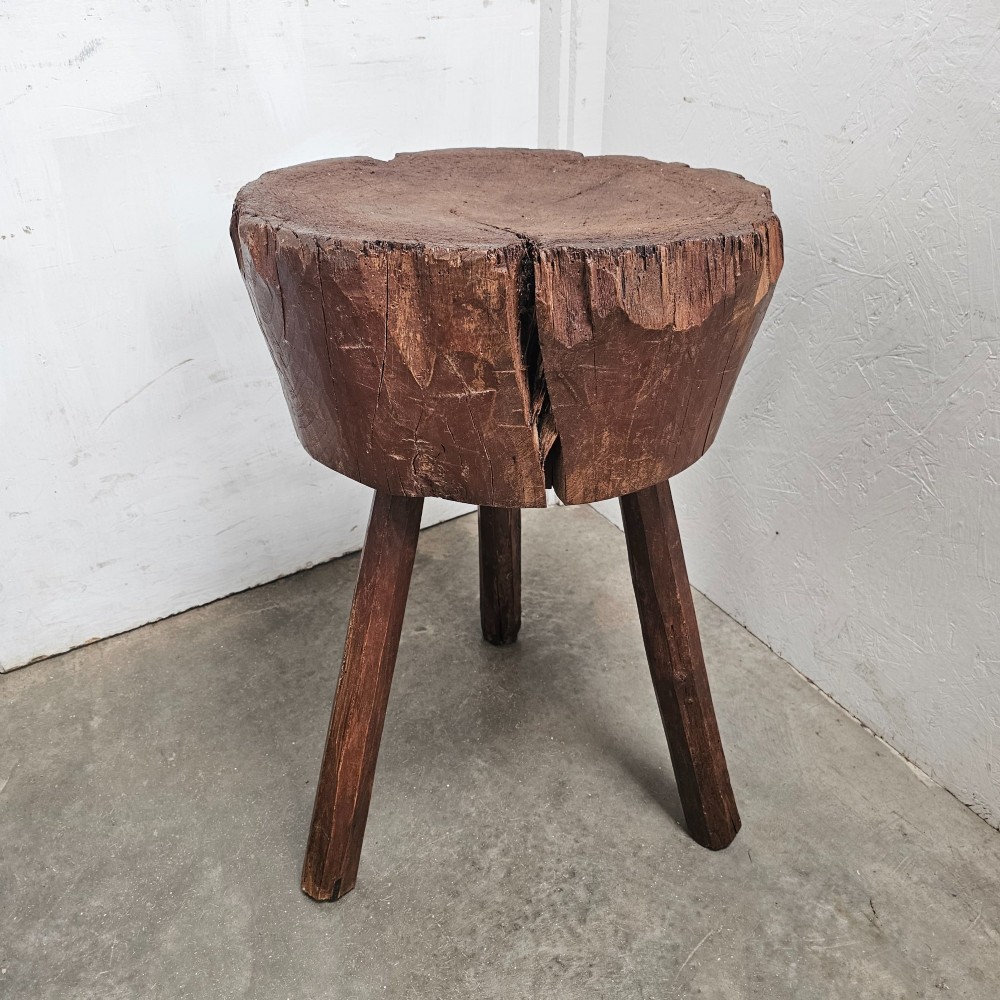 A primitive French beech game block with a carved timber top supported by three splayed wooden legs. View II