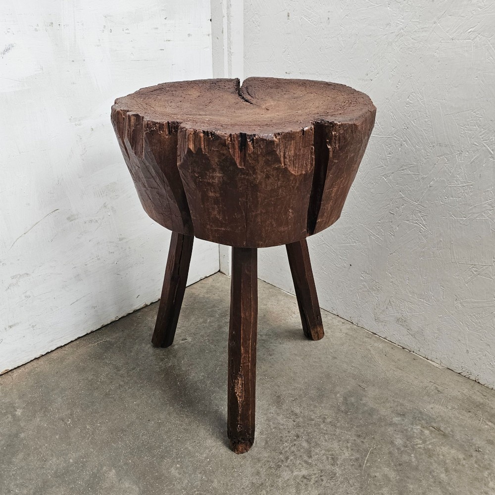 A primitive French beech game block with a carved timber top supported by three splayed wooden legs. View V