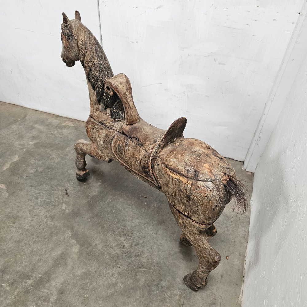 A 19th-century French hand-carved wooden carousel horse featuring a prancing pose, carved saddle, black painted mane, and weathered grey-brown timber finish. View II