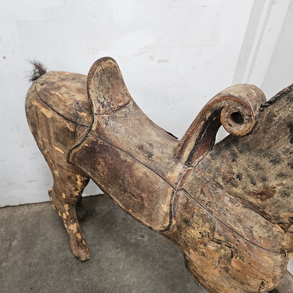A 19th-century French hand-carved wooden carousel horse featuring a prancing pose, carved saddle, black painted mane, and weathered grey-brown timber finish. View IV