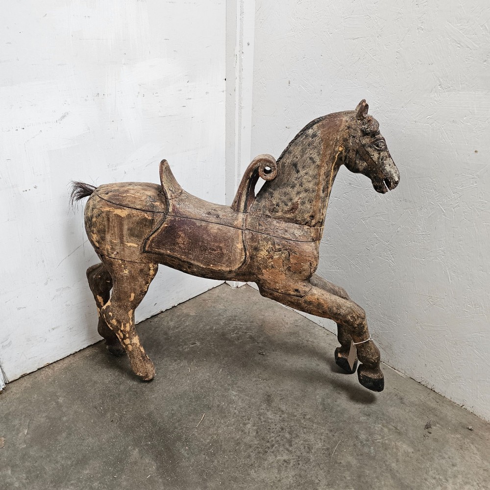 A 19th-century French hand-carved wooden carousel horse featuring a prancing pose, carved saddle, black painted mane, and weathered grey-brown timber finish. View VI