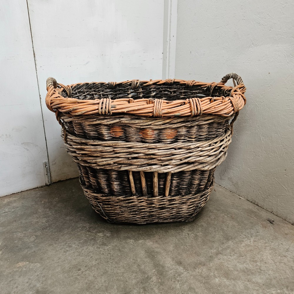A large, rustic hand-woven willow French champagne harvest basket with woven rim detailing and integrated side handles. View II
