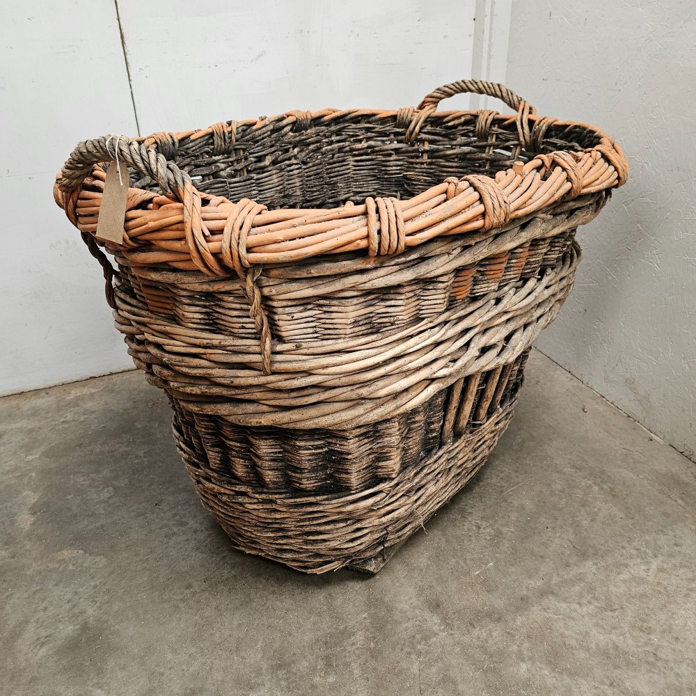 A large, rustic hand-woven willow French champagne harvest basket with woven rim detailing and integrated side handles.