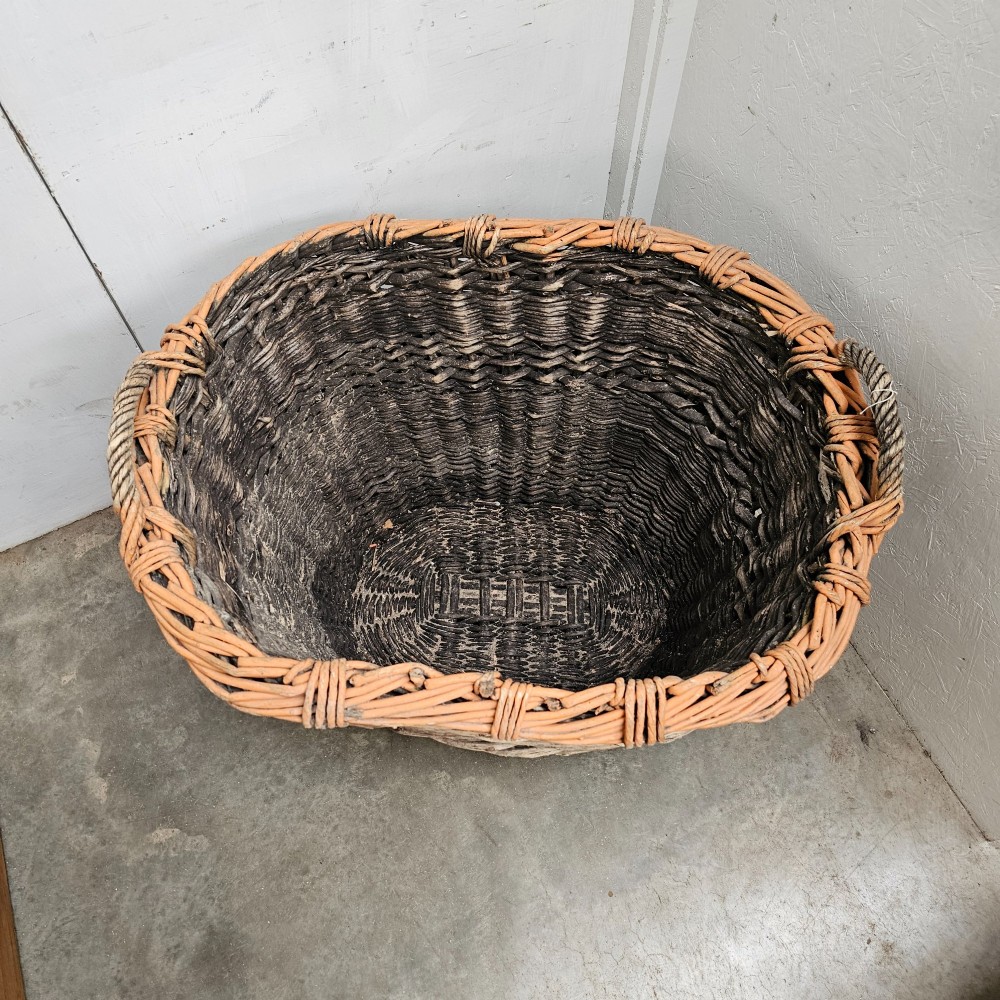 A large, rustic hand-woven willow French champagne harvest basket with woven rim detailing and integrated side handles. View IV