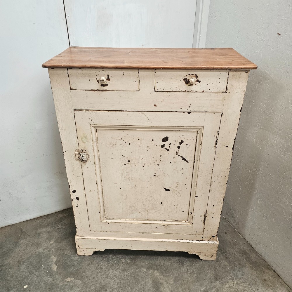 A small painted pine French confiturier cupboard with two upper drawers, a single panelled door, an off-white distressed paint finish, and a natural timber top surface.