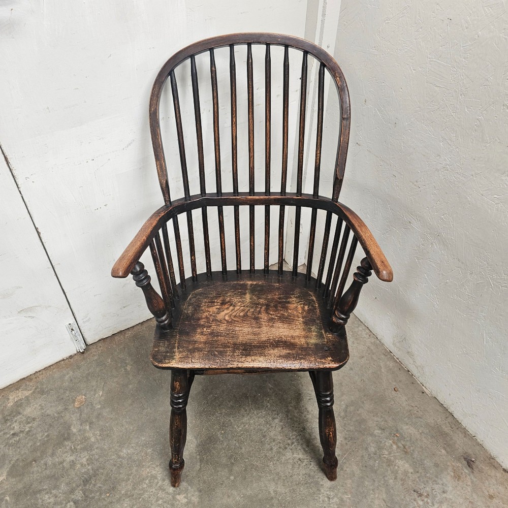 An antique dark brown oak and ash Windsor armchair featuring a high hoop back with vertical spindles, turned legs, and a shaped solid wood seat. View VI