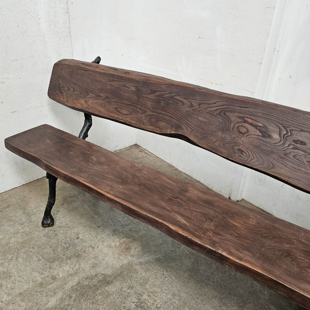 A rustic French garden bench featuring a dark elm slab seat and backrest supported by black cast iron legs designed to resemble natural tree branches. View IV