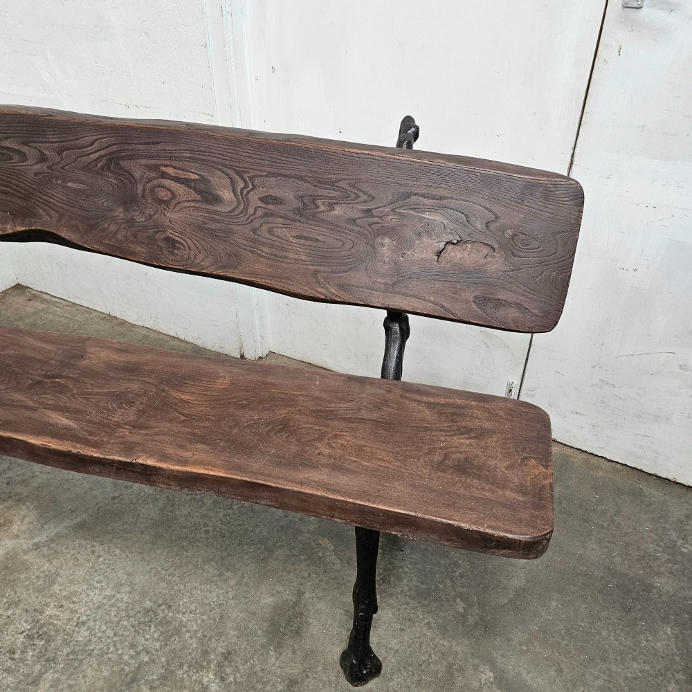 A rustic French garden bench featuring a dark elm slab seat and backrest supported by black cast iron legs designed to resemble natural tree branches. View V