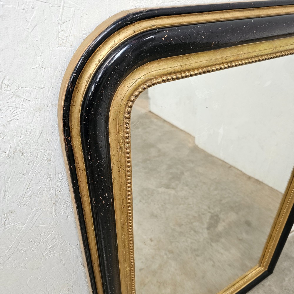 A rectangular French Louis Philippe mirror featuring rounded upper corners, an ebonised black outer frame, and a beaded gold leaf inner trim. View V