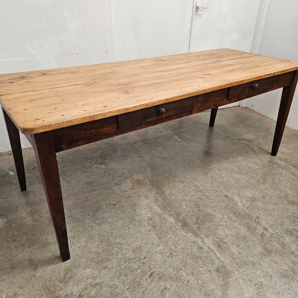 An antique French farmhouse dining table with a light pine plank top, two apron drawers, and a dark oak frame with tapered legs. View II
