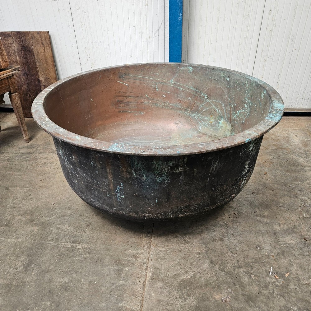 A massive antique French copper cheese vat with a reinforced rim, showing an oxidised exterior with verdigris green highlights. View IV