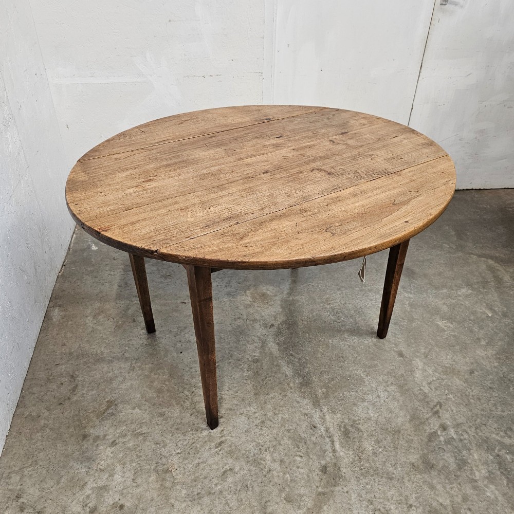 An antique wooden French drop-leaf table with semi-circular side leaves folded down and four tapered wooden legs. View III