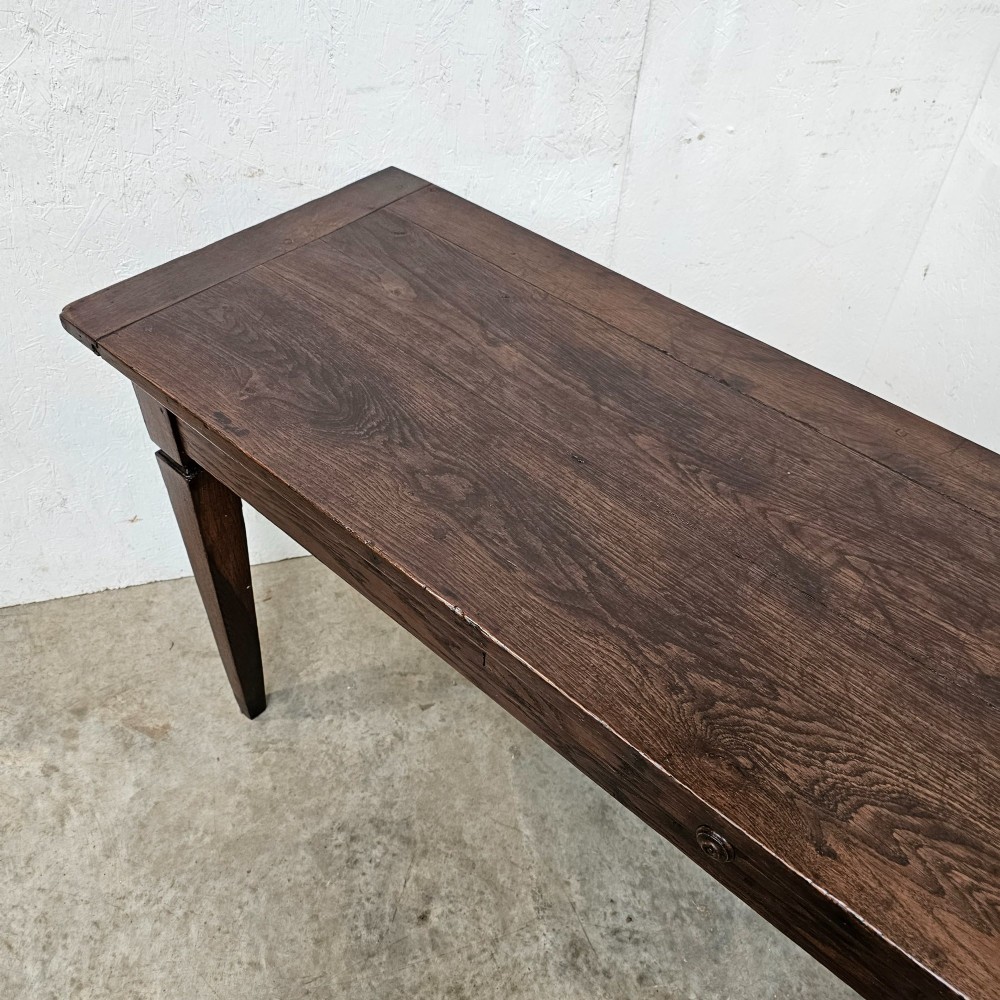 A rectangular dark oak console table featuring four square tapered legs, a single central drawer with a wooden knob, and a flat timber top. View III