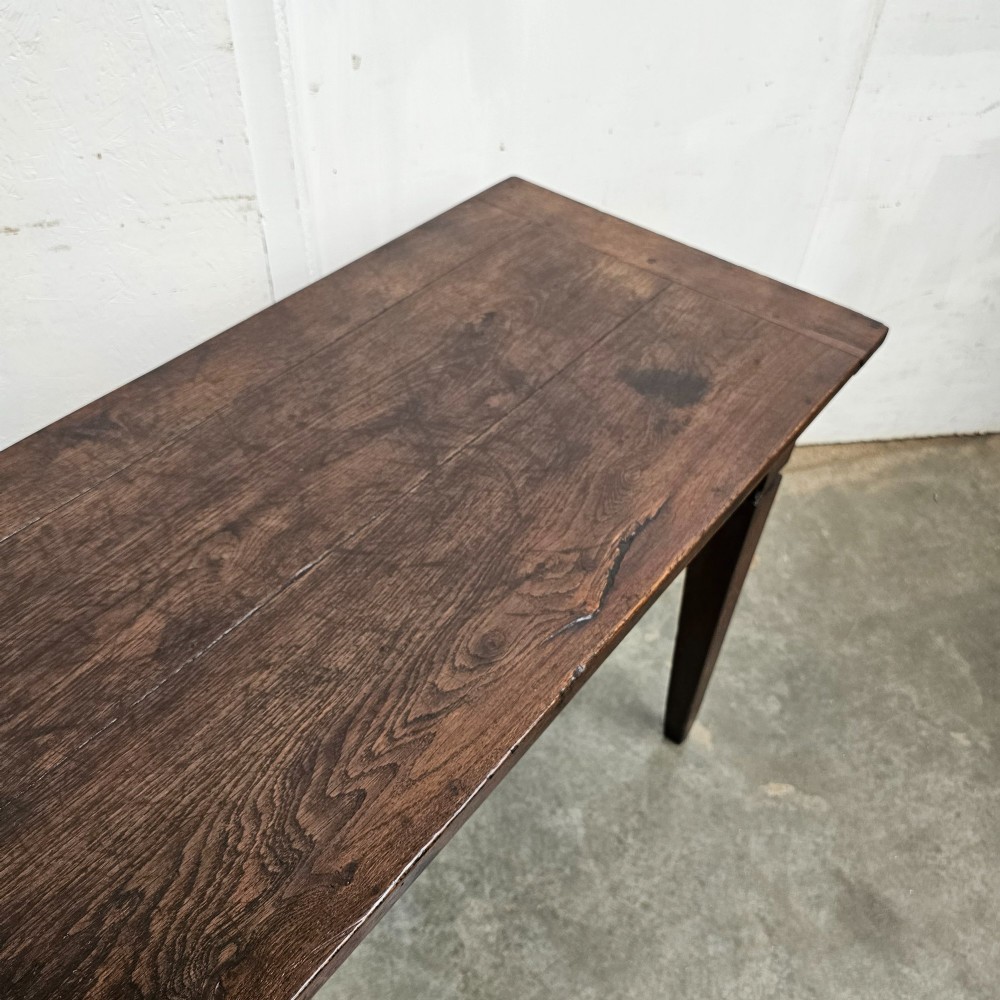 A rectangular dark oak console table featuring four square tapered legs, a single central drawer with a wooden knob, and a flat timber top. View IV