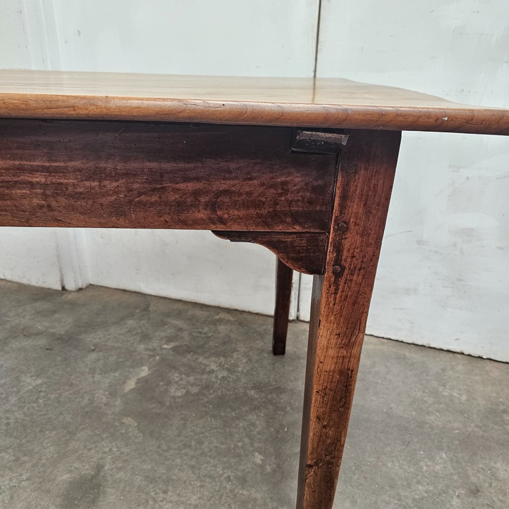 A rectangular French cherrywood farmhouse dining table featuring a plank top, simple apron, and four tapered square legs. View III