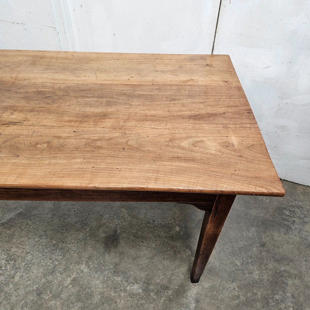 A rectangular French cherrywood farmhouse dining table featuring a plank top, simple apron, and four tapered square legs. View V