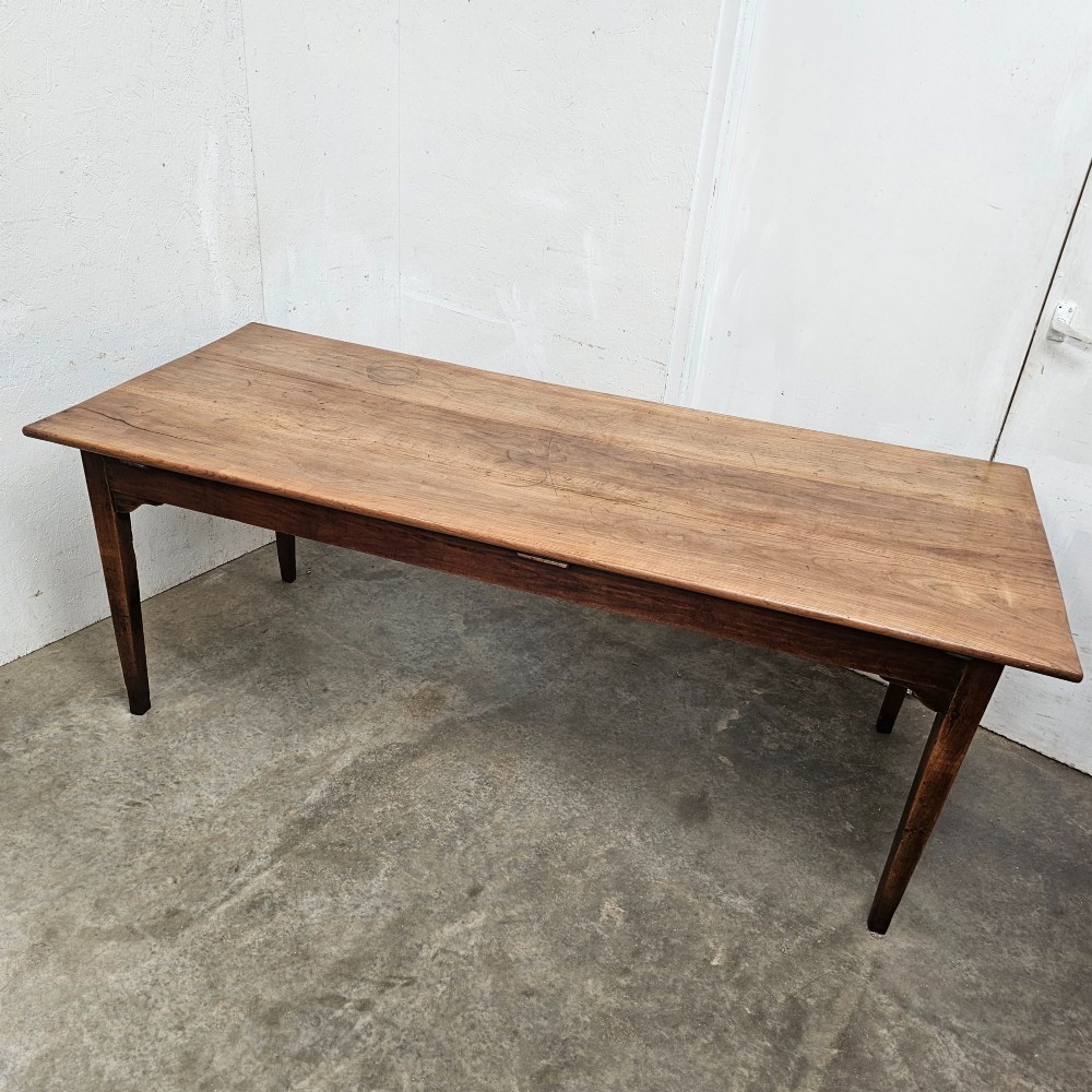 A rectangular French cherrywood farmhouse dining table featuring a plank top, simple apron, and four tapered square legs. View VI