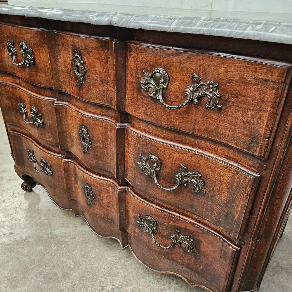 An 18th-century French provincial walnut commode with a shaped grey marble top, serpentine drawer fronts, bronze handles, and short cabriole legs. View II