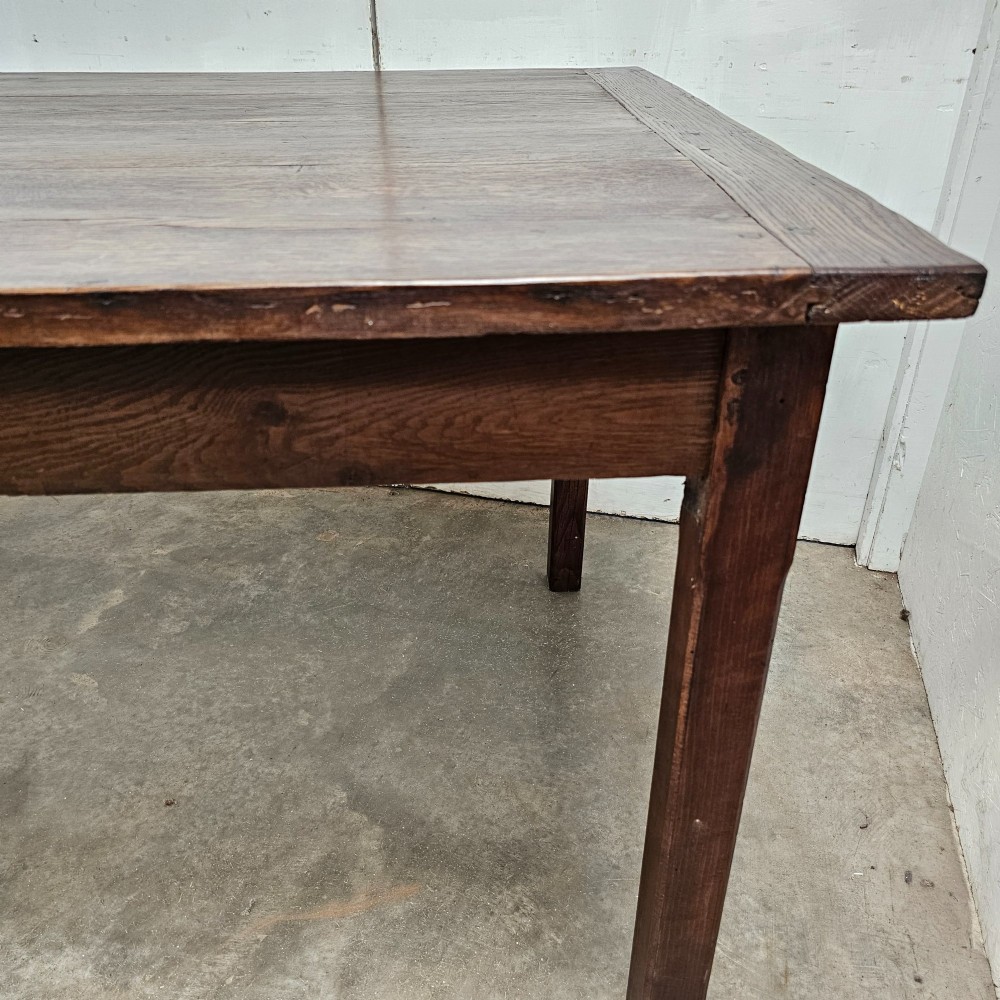 An eight-foot French oak farmhouse dining table with a dark patinated plank top, breadboard ends, and sturdy legs. View V