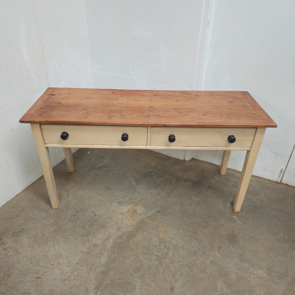 A nineteenth-century English painted pine dairy table with a natural timber top, a cream painted base, double drawers, and dark turned wooden knobs. View III