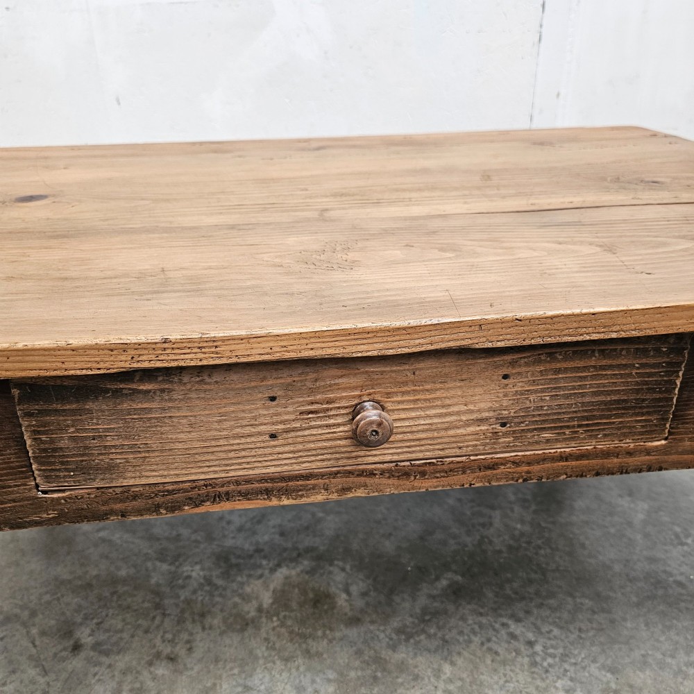 A rectangular rustic pine coffee table featuring four turned legs and a single central frieze drawer with a round wooden knob. View V