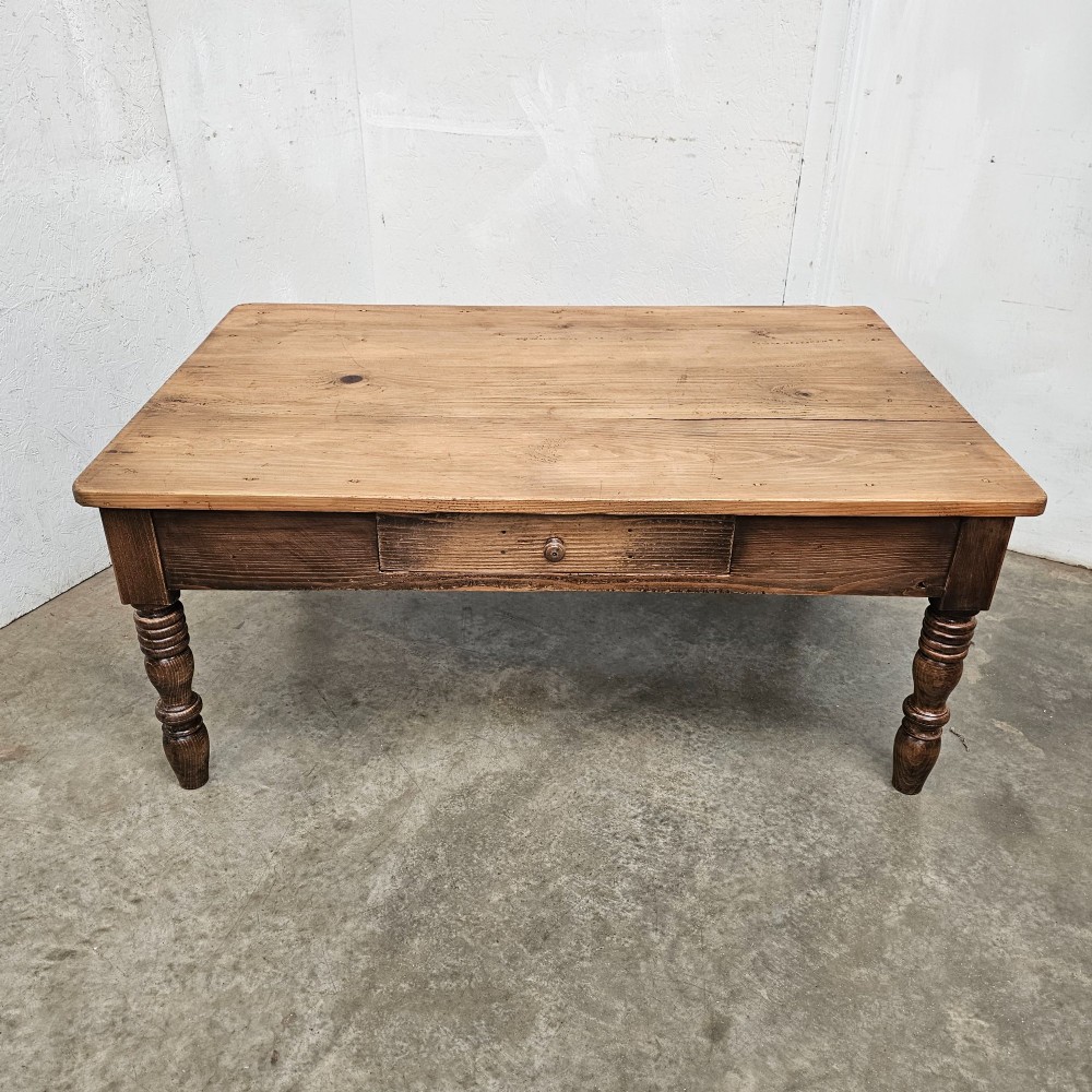 A rectangular rustic pine coffee table featuring four turned legs and a single central frieze drawer with a round wooden knob. View VI
