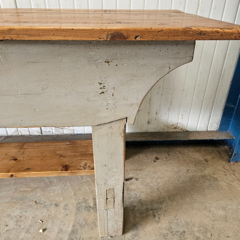 A long rustic pine worktable featuring a natural wood top, a light grey painted frame with a single drawer, and a lower shelf. View V