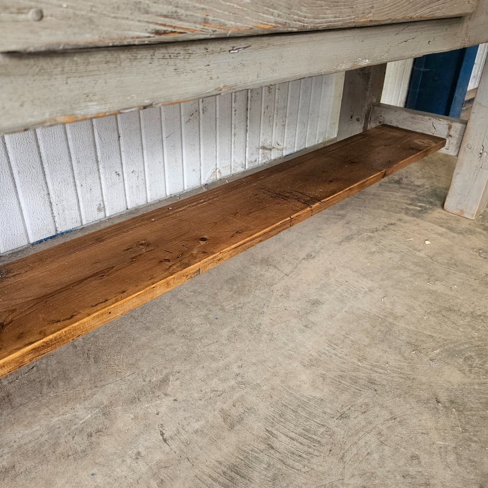 A long rustic pine worktable featuring a natural wood top, a light grey painted frame with a single drawer, and a lower shelf. View VI