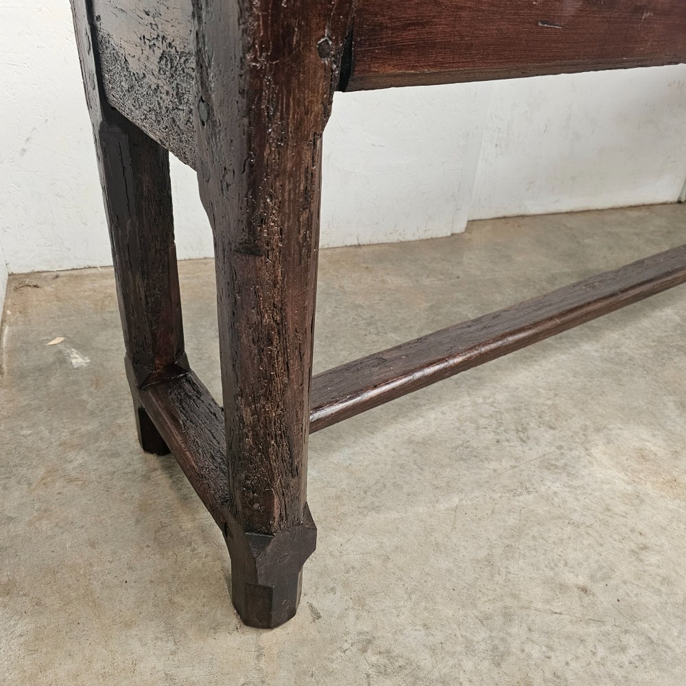 An antique dark fruitwood console table featuring a single central drawer, straight legs, and an H-stretcher base. View V