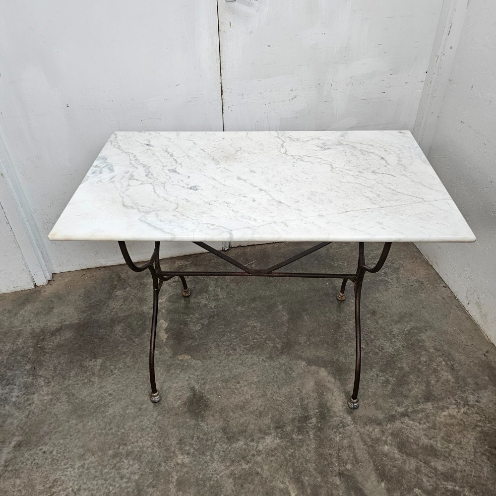 A rectangular white veined marble top resting on a dark wrought iron base with curved legs and cross-bracing. View II