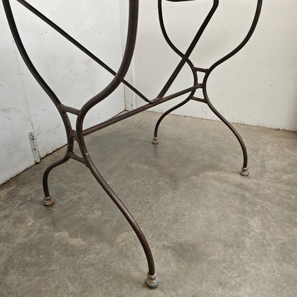 A rectangular white veined marble top resting on a dark wrought iron base with curved legs and cross-bracing. View III