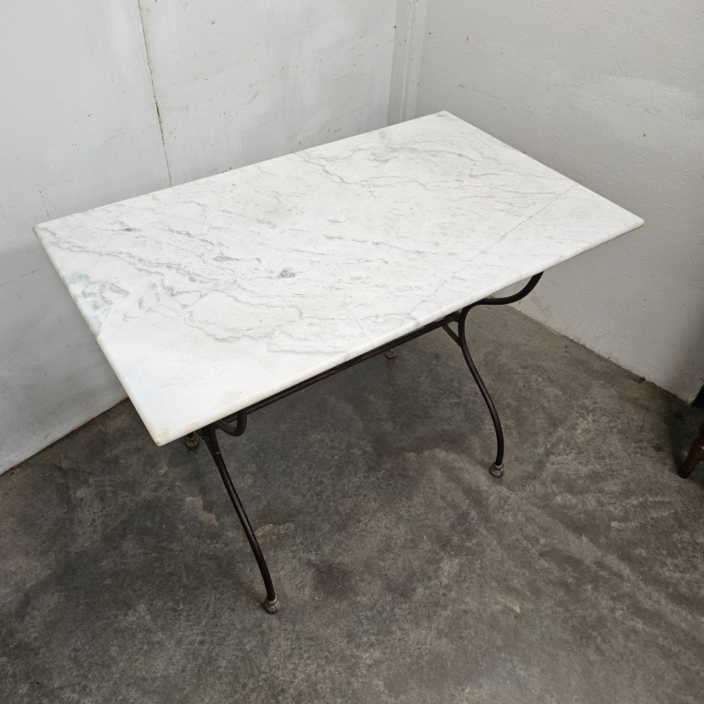 A rectangular white veined marble top resting on a dark wrought iron base with curved legs and cross-bracing. View IV